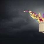 A hand holds out a brown box that has colors exploding from within