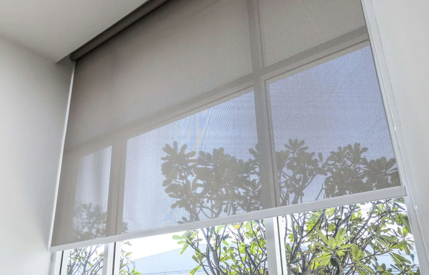 Roll Blinds On The Windows, The Sun Does Not Penetrate The House. Window In The Interior Roller Blinds. Beautiful Blinds On The Window, The Sun And Heat Protection, The Perfect Windows Interior Decor A sleek, modern living room showcasing elegant, motorized window coverings.