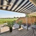 Black and white striped retractable awning installed on patio of home