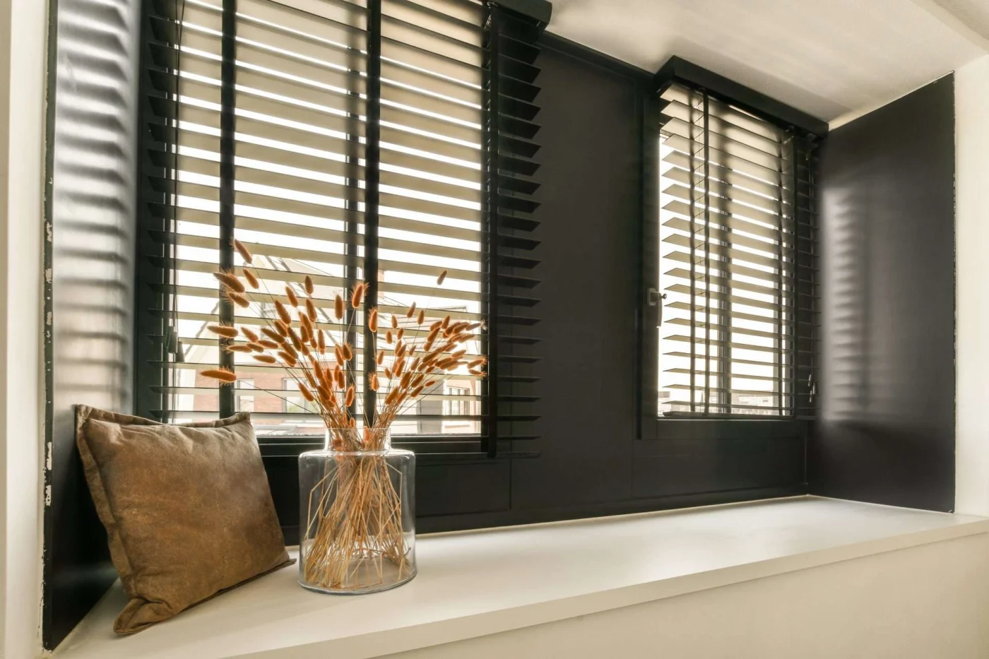 Plantation shutters in upscale home with decorative vase in foreground in San Pablo, CA by The Home Living Company