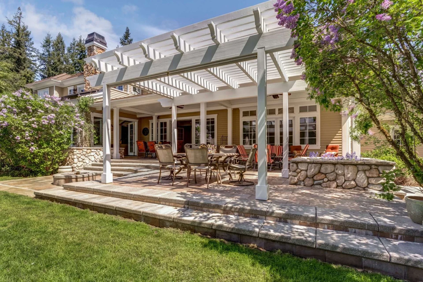 White pergola attached to house with garden in San Pablo, CA by The Home Living Company