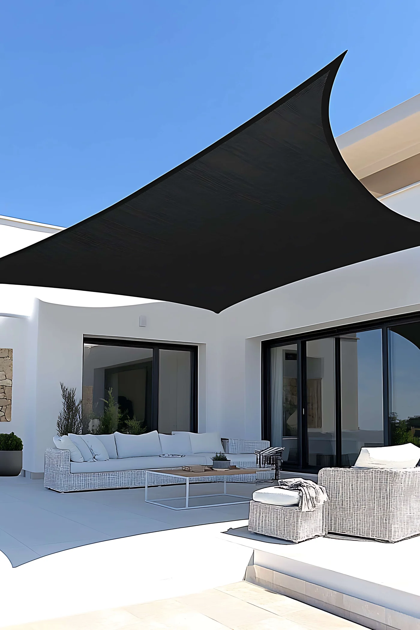 Black sail shade on patio protecting furniture
