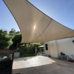 A dramatic, light brown Australian sail shade over a greater San Francisco Bay area patio in CA