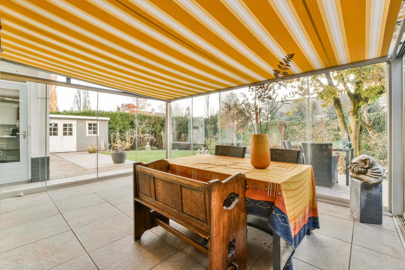 Excellent Awning In San Francisco, CA The image features a backyard hangout area with a yellow and white striped awning.