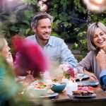 A group of people sit around a patio table enjoying the outdoor space
